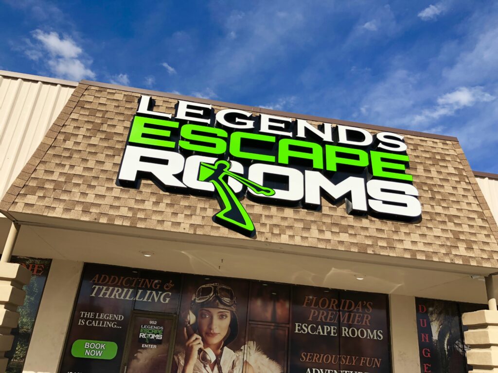 Bright sign for "Legends Escape Rooms" showcases Florida's premier escape room experience. Features promotional text highlighting excitement and adventure.